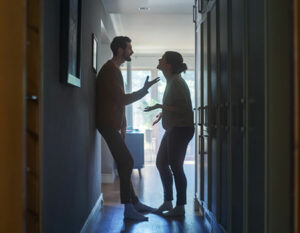 An image of a couple arguing in a hallway