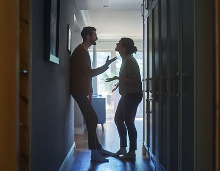 An image of a couple arguing in a hallway