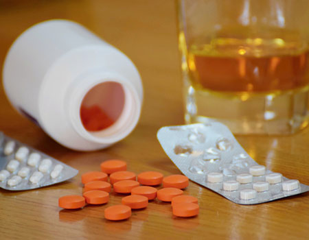An image of pills and drink on a table