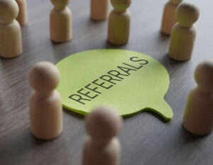 An image of people people around a speech bubble with Referrals written on 