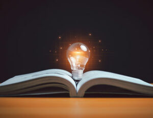 An image of a light bulb hovering over an open book