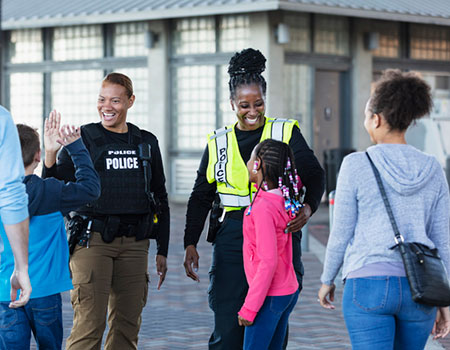 An image of a family outside talking to two police officers with smiles on their faces