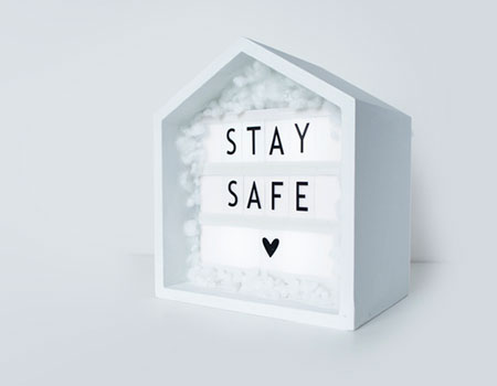 An image of a while wooden house with Stay Safe inside it