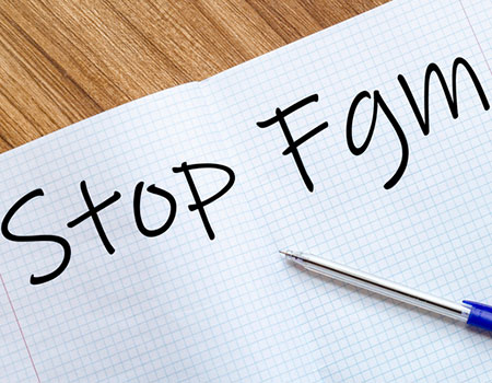 An image of the words STOP FGM written in an exercise book