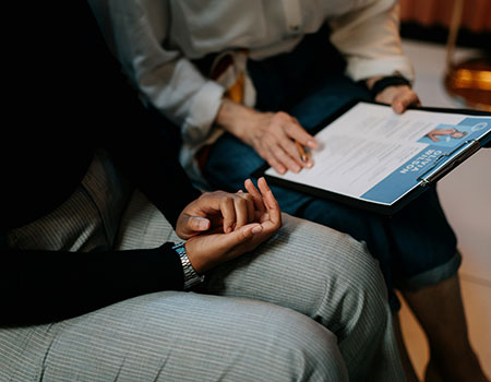 Two people sat looking at a clipboard with a report on it.