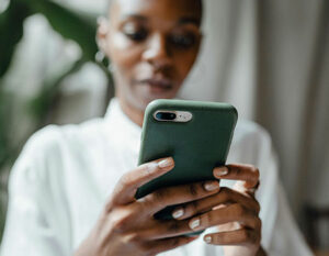 An image of a lady typing on a mobile phone.