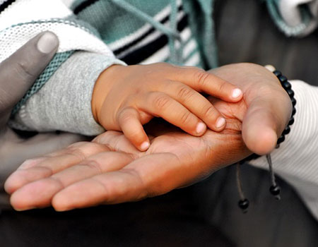 An image of different size hands on top of each other.